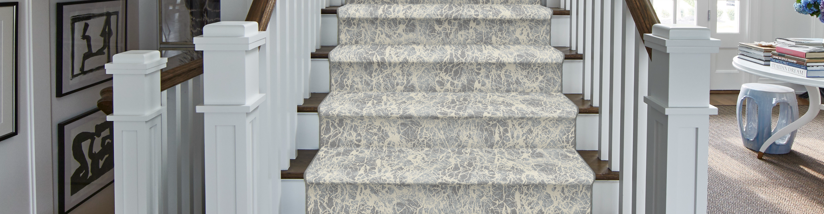 Hardwood stairs with cream patterned carpet runner. 